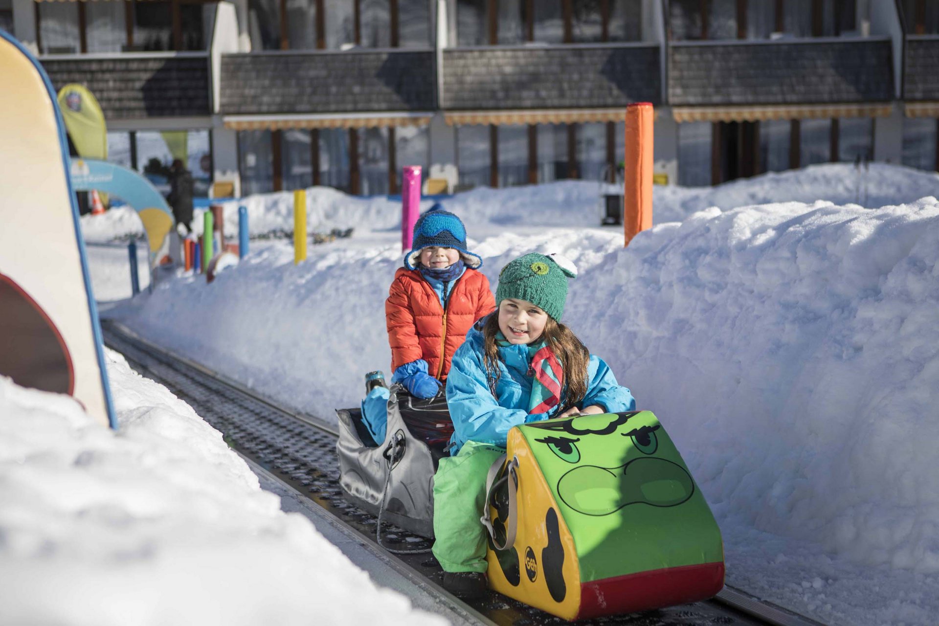 Bambini su un trenino su rotaie in un paesaggio innevato