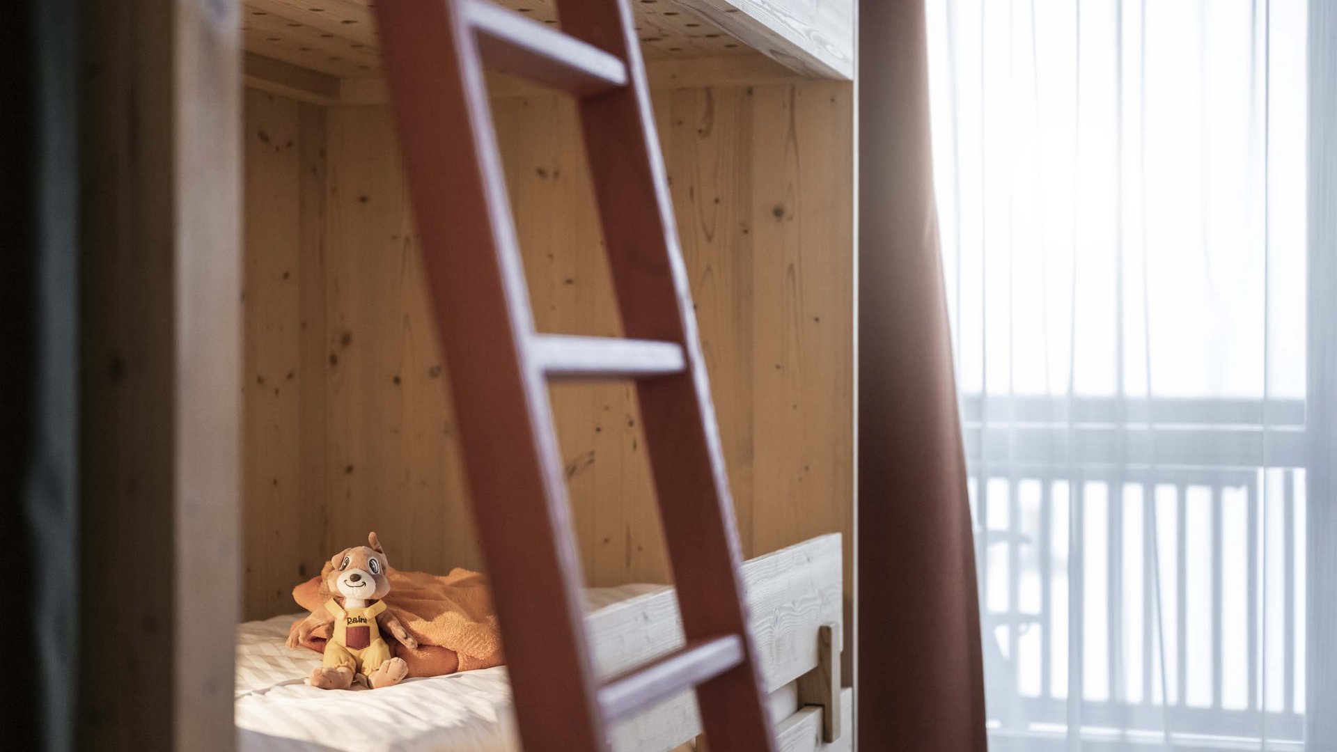 Family Resort Rainer Peluche a forma di cane su un letto a castello in legno