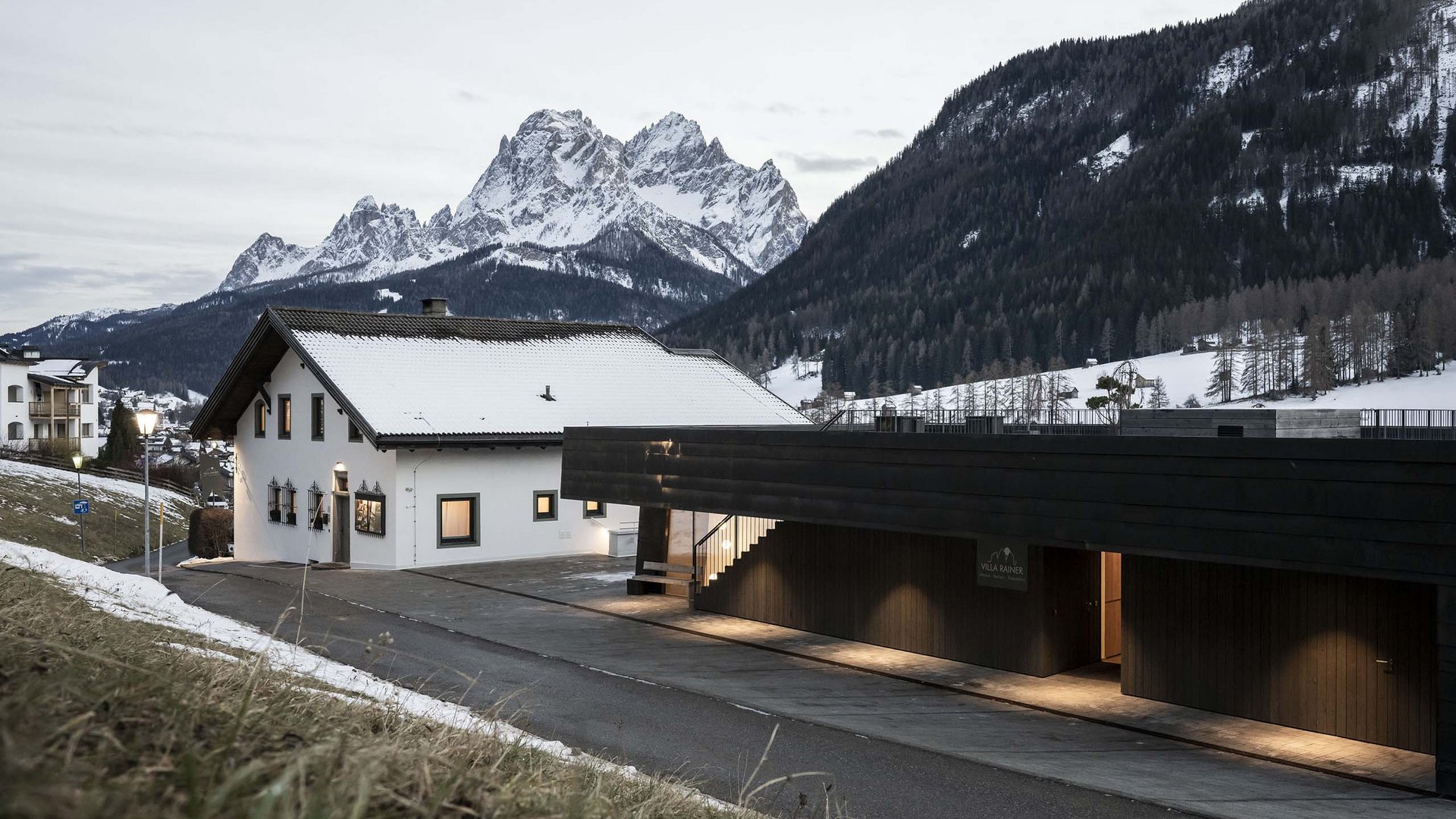 Residence Villa Rainer Case innevate davanti alle montagne in un paesaggio invernale