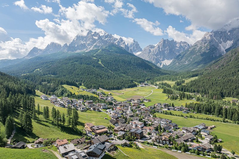 Suggerimenti esclusivi per i vostri tour Vista di un villaggio in una valle verde con montagne e cielo nuvoloso