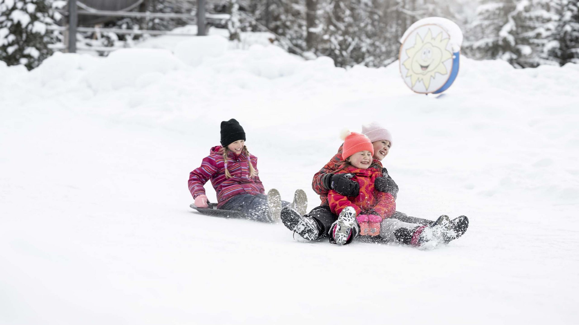 Qualche immagine del Rainer Tre bambini slittano insieme nella foresta innevata.