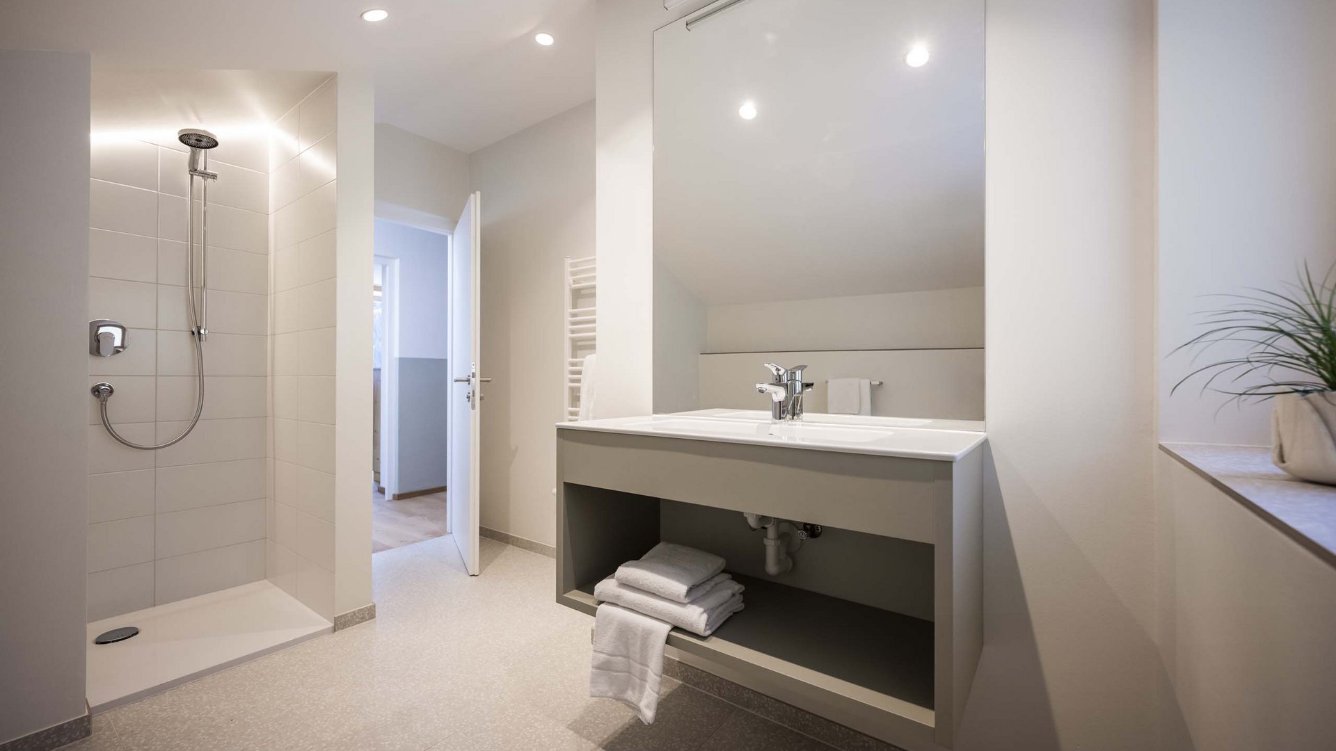 Residence Villa Rainer Bagno moderno con doccia, lavabo e asciugamani piegati