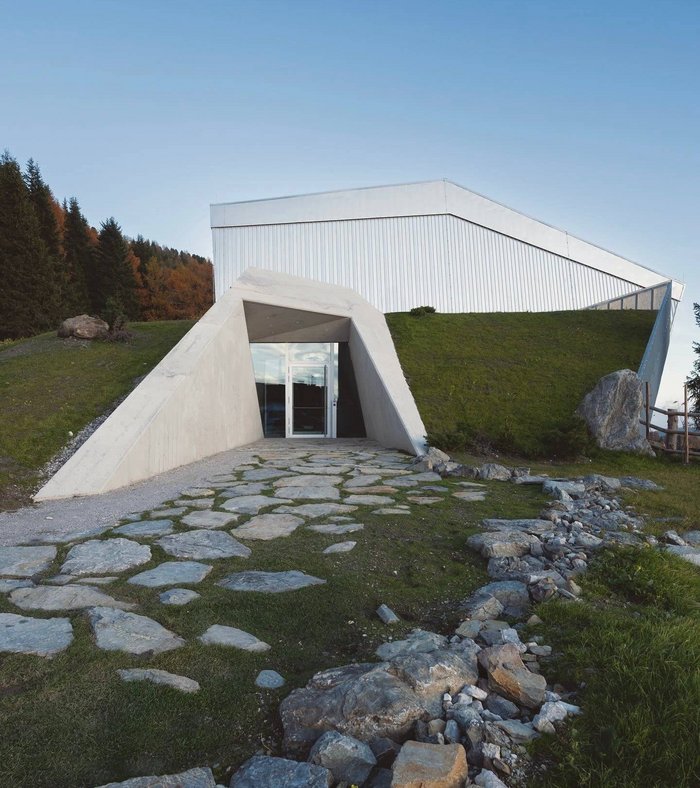 Sights around Sexten Modern building with flat roof and stone path in green landscape