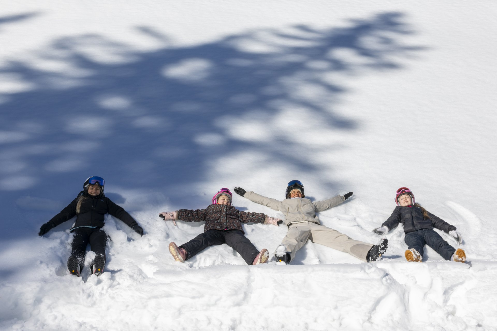 Il vostro family resort in Alto Adige Quattro persone sdraiate sulla neve fanno angeli di neve