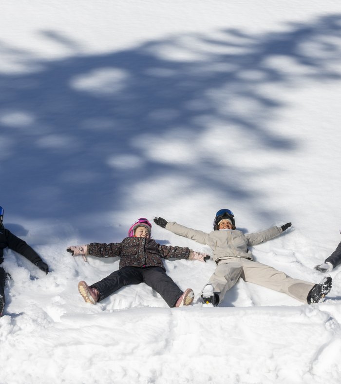 Il vostro family resort in Alto Adige Quattro persone sdraiate sulla neve fanno angeli di neve
