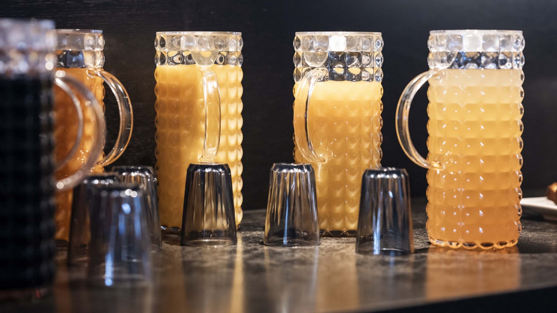 Family Resort Rainer Boccali trasparenti con succo d'arancia e bicchieri rovesciati davanti