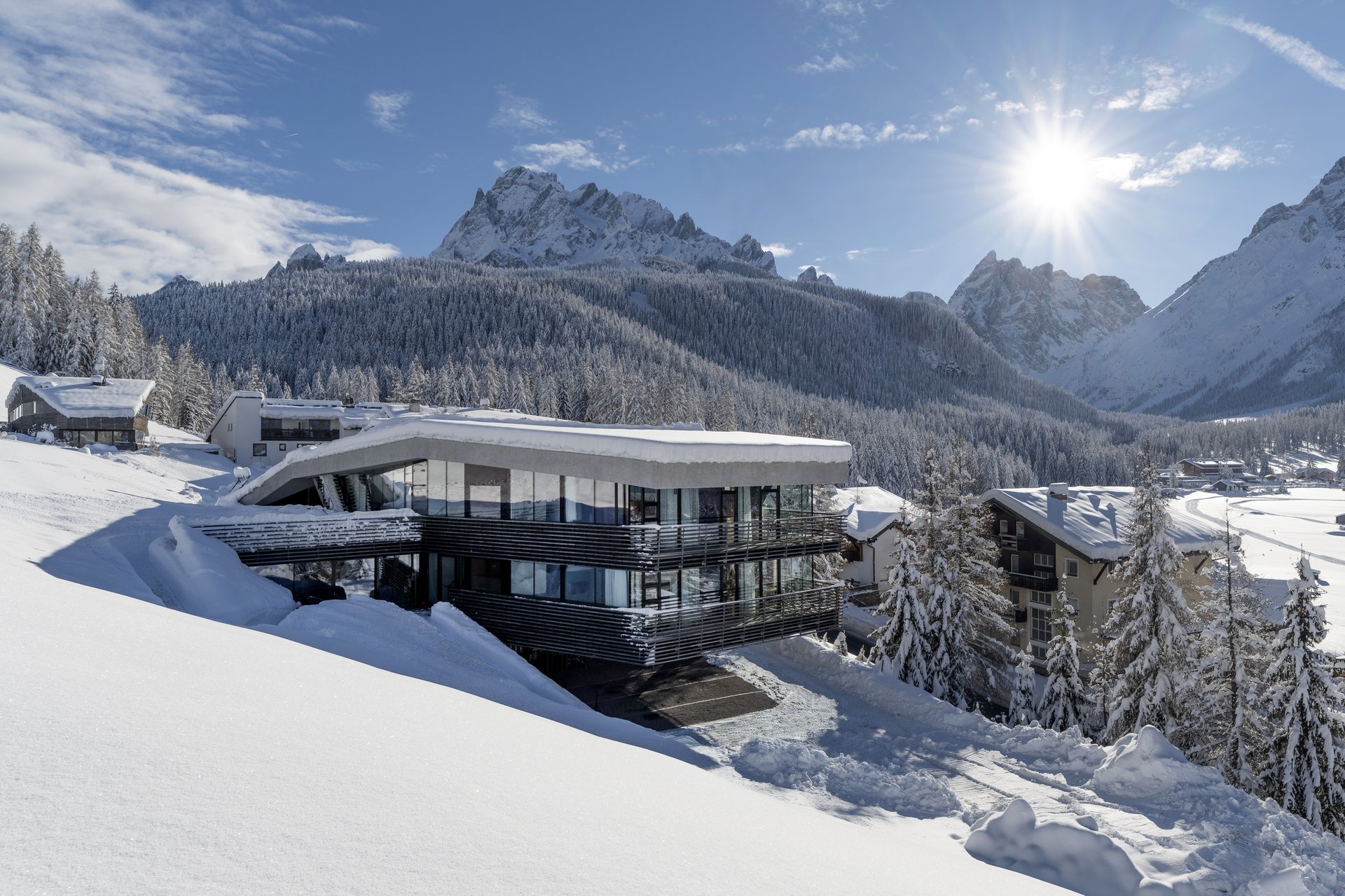 Modernes Haus im Schnee mit Blick auf schneebedeckte Berge und Wald