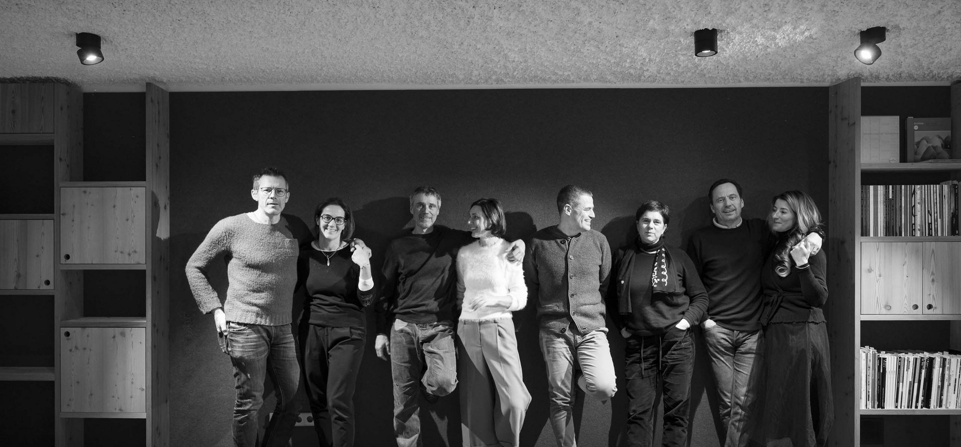 Ihr Familienresort in Südtirol Acht Menschen stehen locker an einer Wand, lächelnd und entspannt