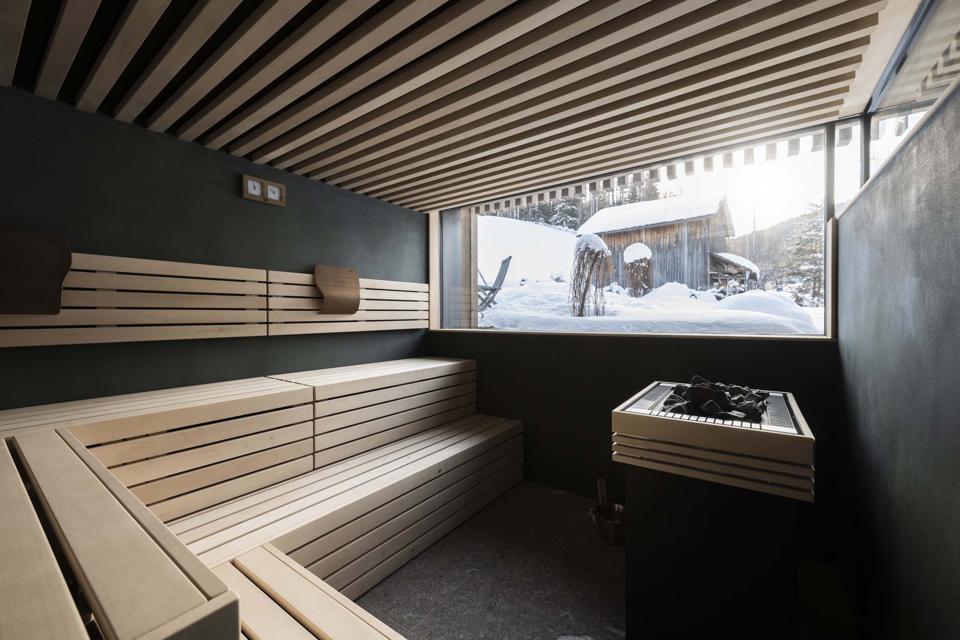 The Residence Königswarte Strata Modern sauna interior with wooden bench and snowy cabin view outside