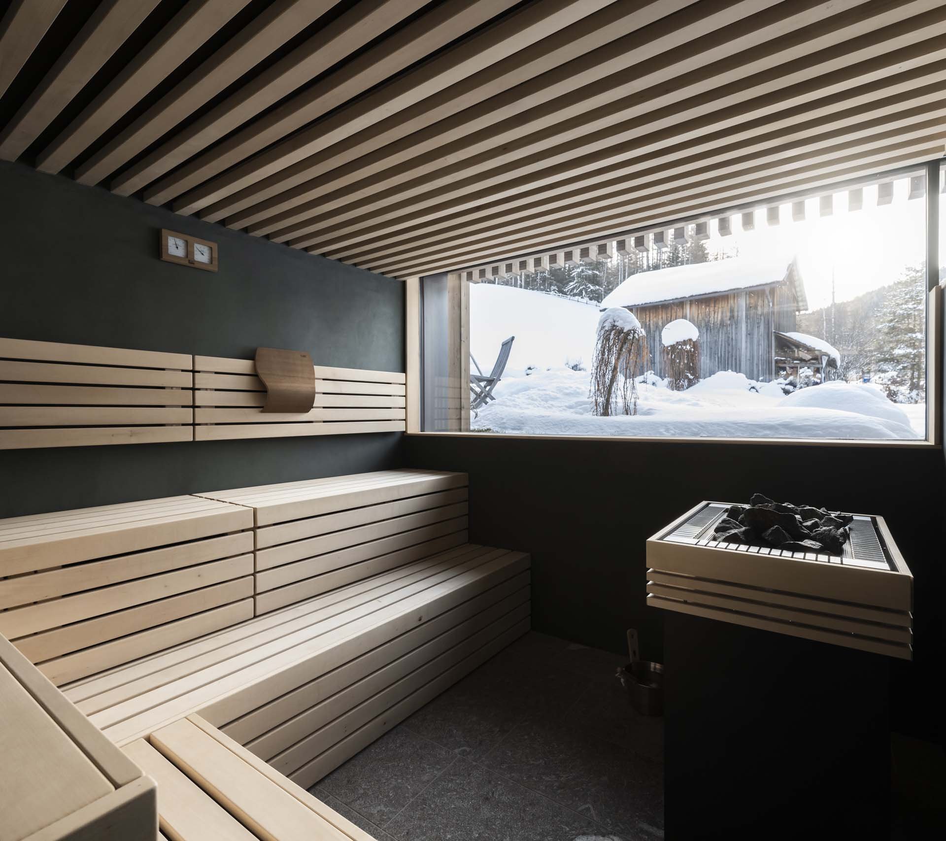 Scheda struttura - Residence Königswarte Strata Interno sauna moderna con panchina in legno e vista su baita innevata