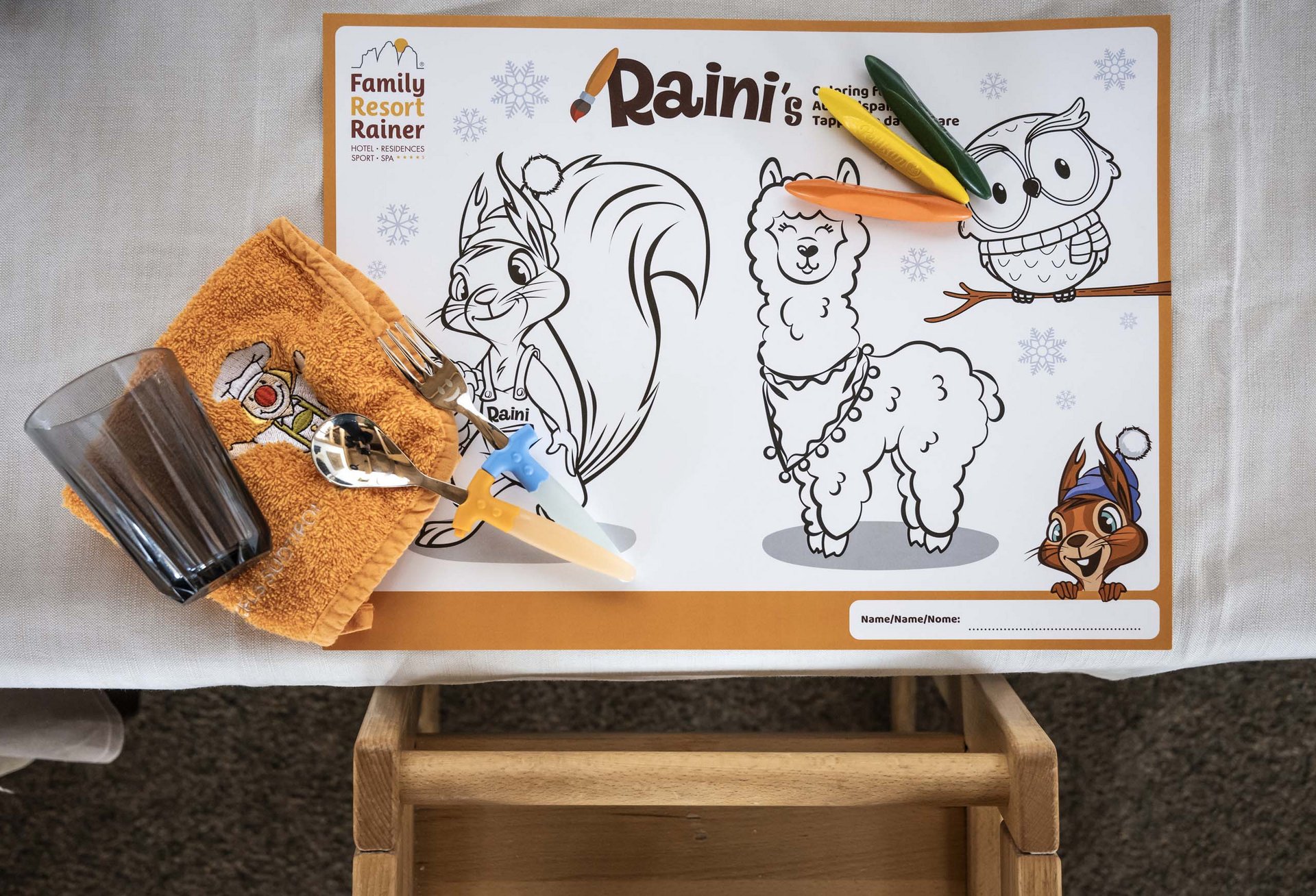 Buffet per bambini al family hotel Rainer Set da tavola per bambini con tovaglietta da colorare, posate e bicchiere al Family Resort Rainer