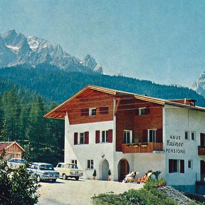 Casa Rainer pensione davanti a montagne boschive sotto il sole