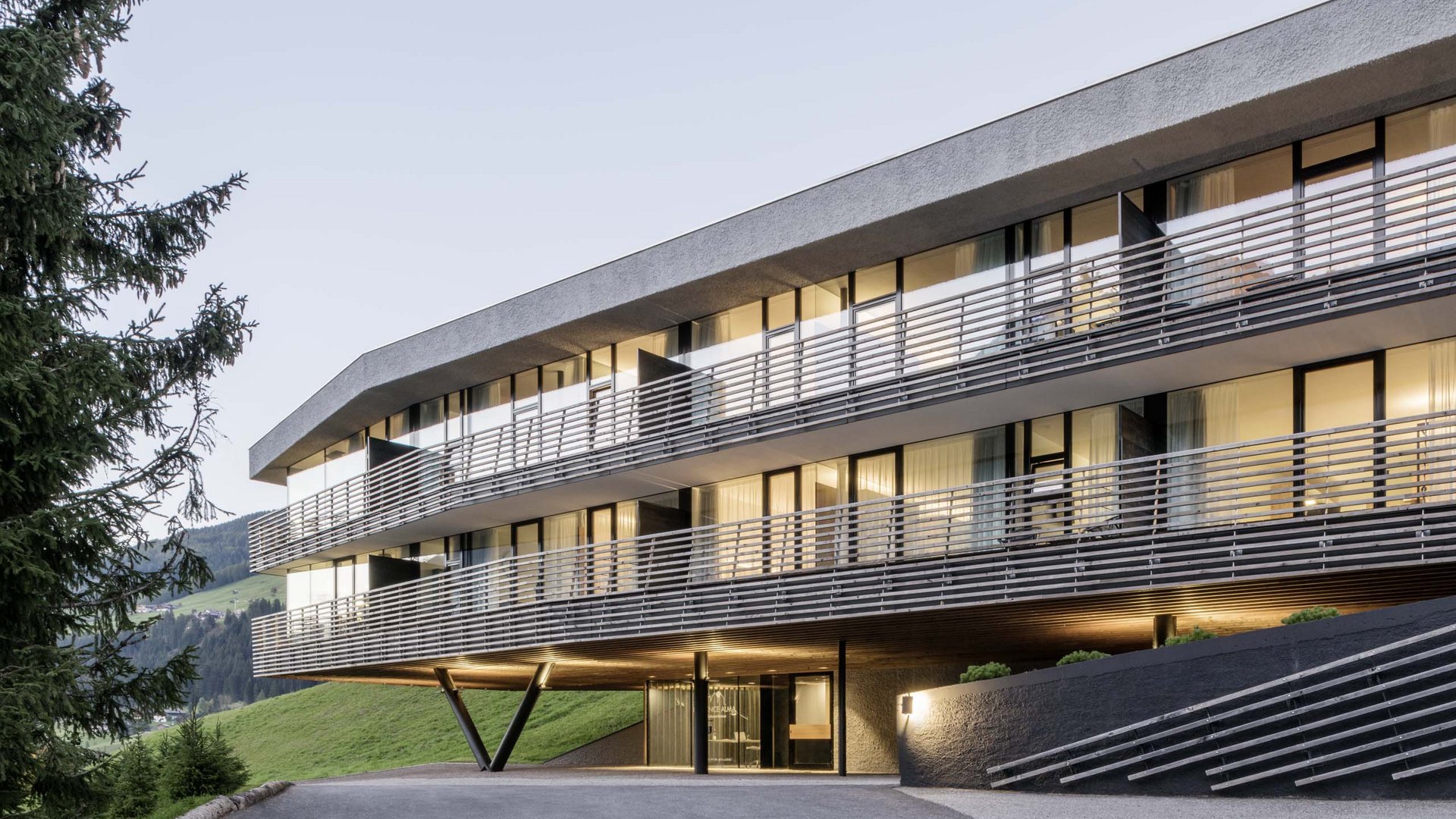Residence Paramount Alma Edificio moderno di un hotel in montagna con finestre illuminate al crepuscolo