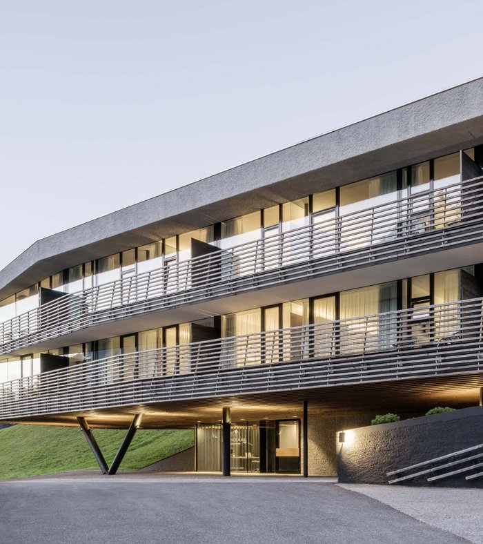 Modern hotel building in mountains with lit windows at dusk
