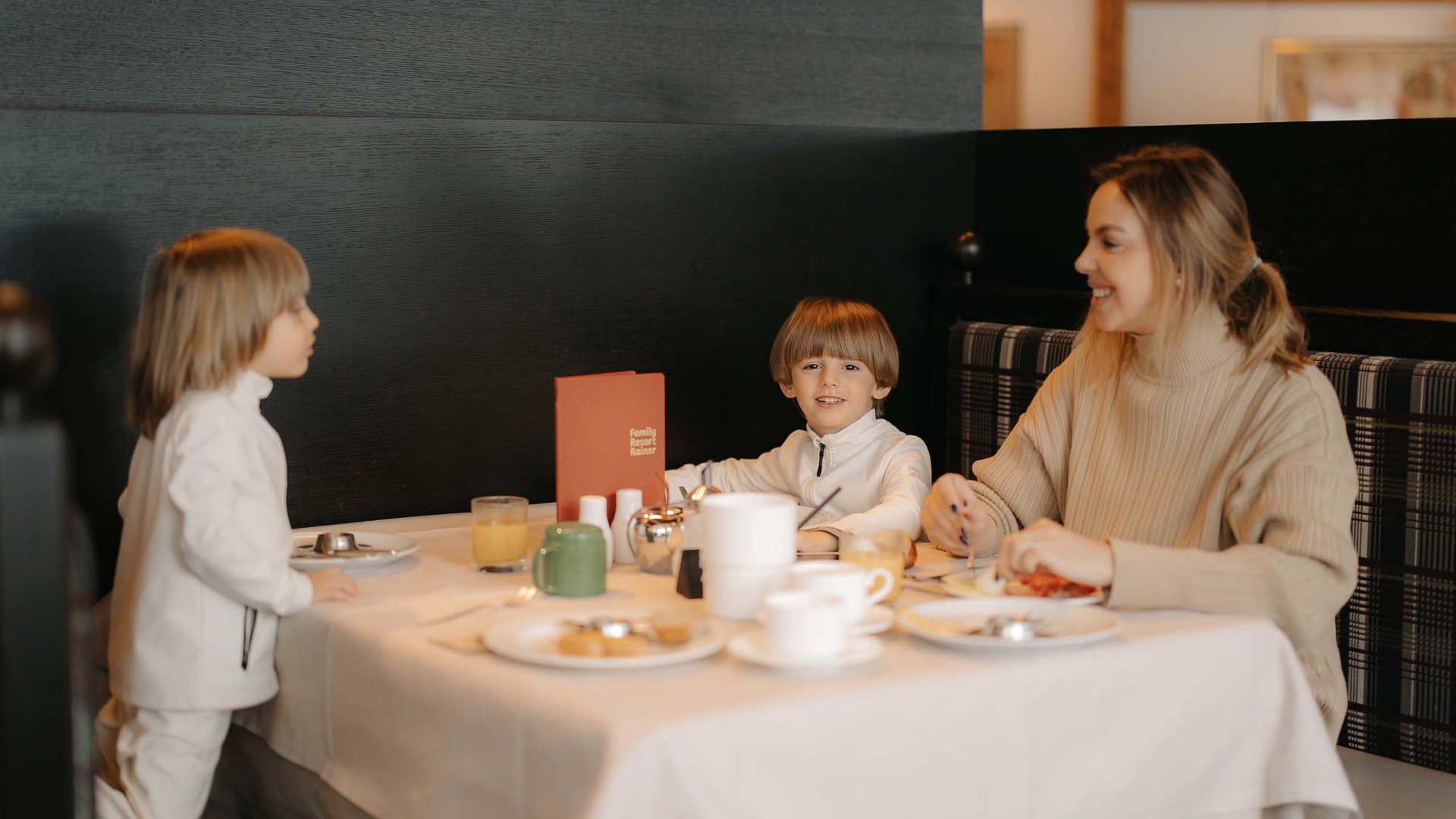 Family Resort Rainer Donna e due bambini fanno colazione in un ristorante