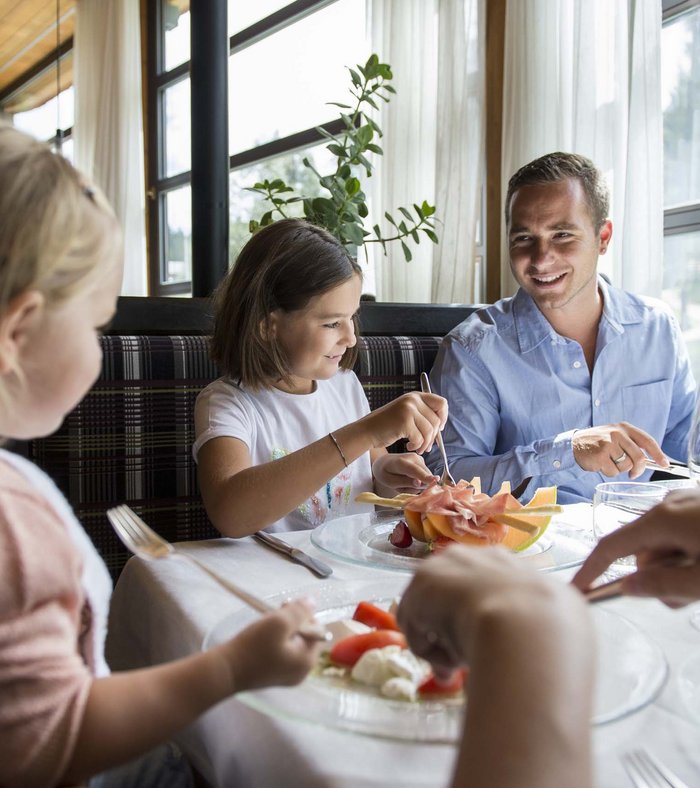 Your fulfilling family holiday Family enjoying a meal together in a bright restaurant