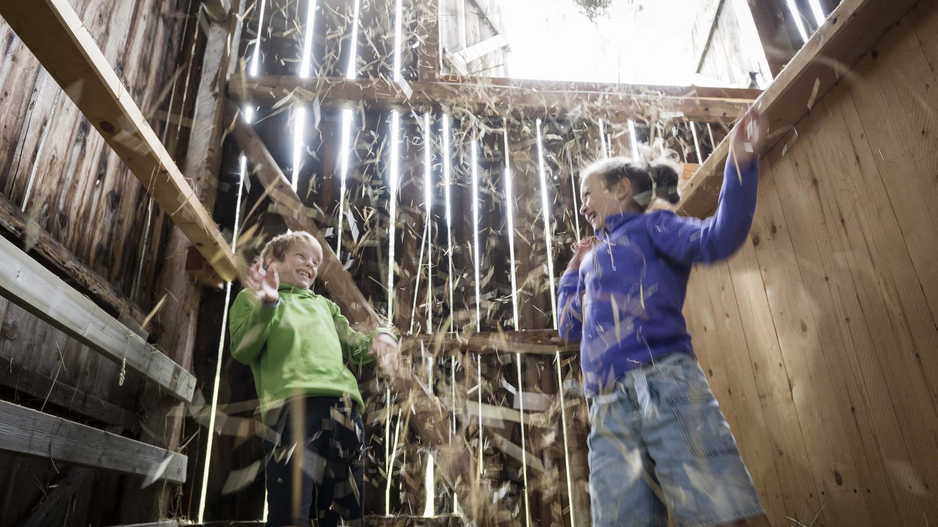 Qualche immagine del Rainer Due bambini che giocano ridendo con la paglia in un fienile