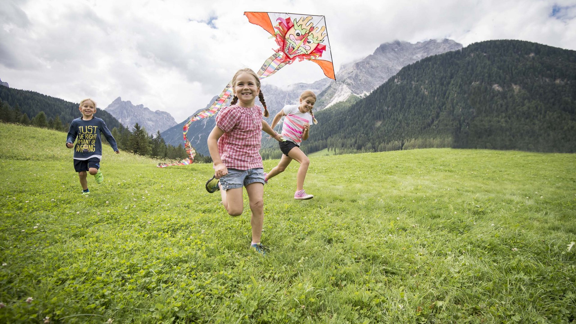 Qualche immagine del Rainer Bambini corrono su un prato mentre fanno volare un aquilone con testa di drago