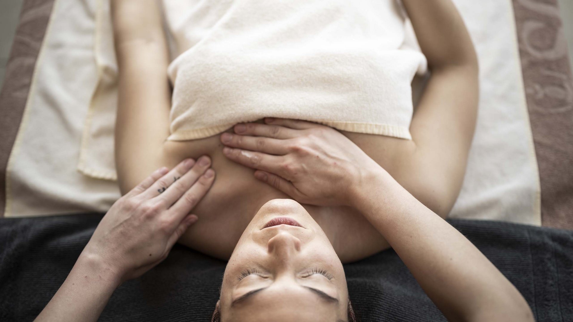 Family Resort Rainer Donna che riceve un massaggio rilassante all'addome su un lettino da massaggio