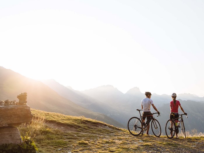 La località perfetta per la mtb: Sesto Due ciclisti con le biciclette sulla montagna al tramonto