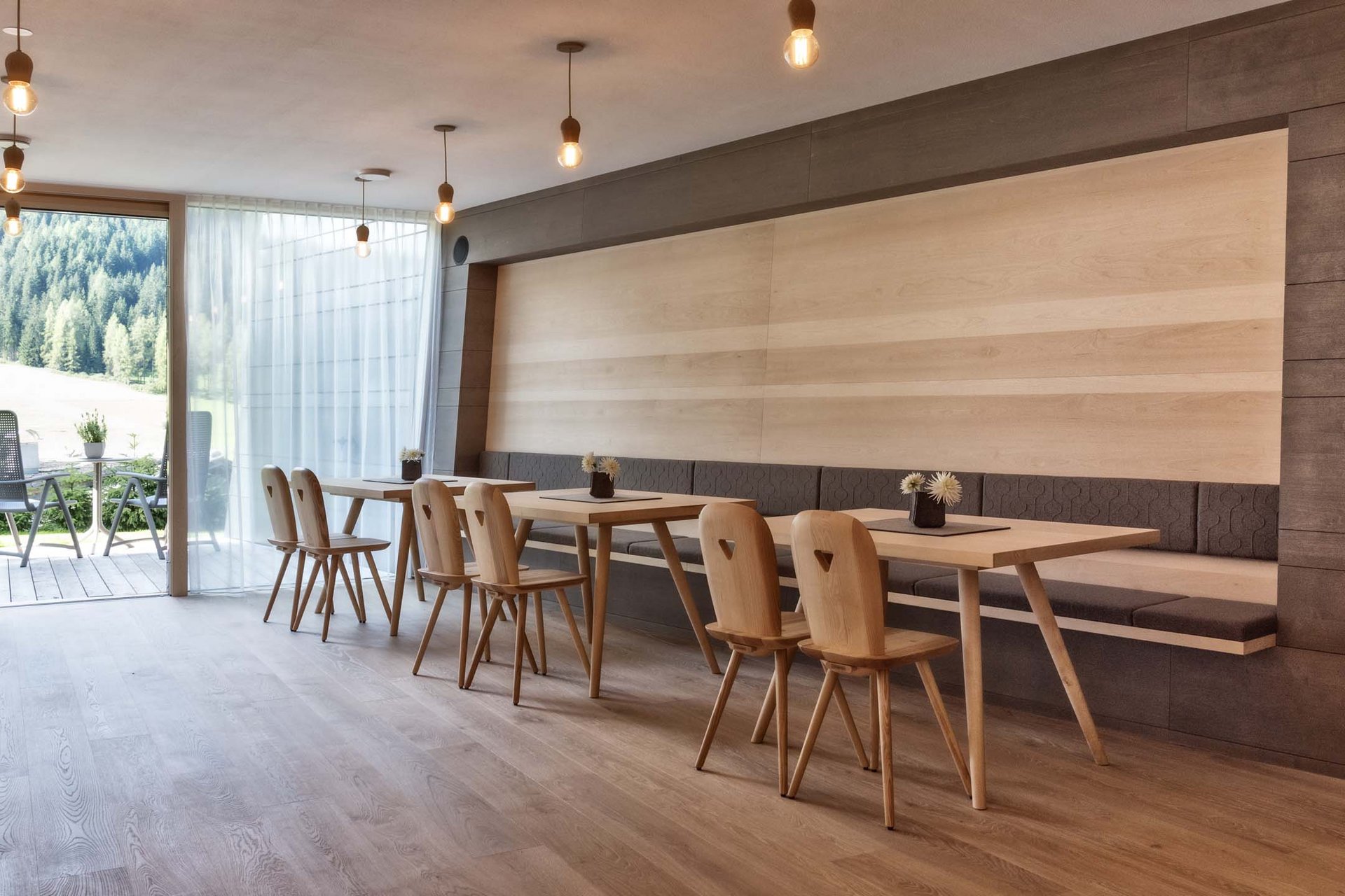 Naturerlebnis in der Villa Rainer Modernes Esszimmer mit Holzmöbeln und Blick auf Terrasse und Wald