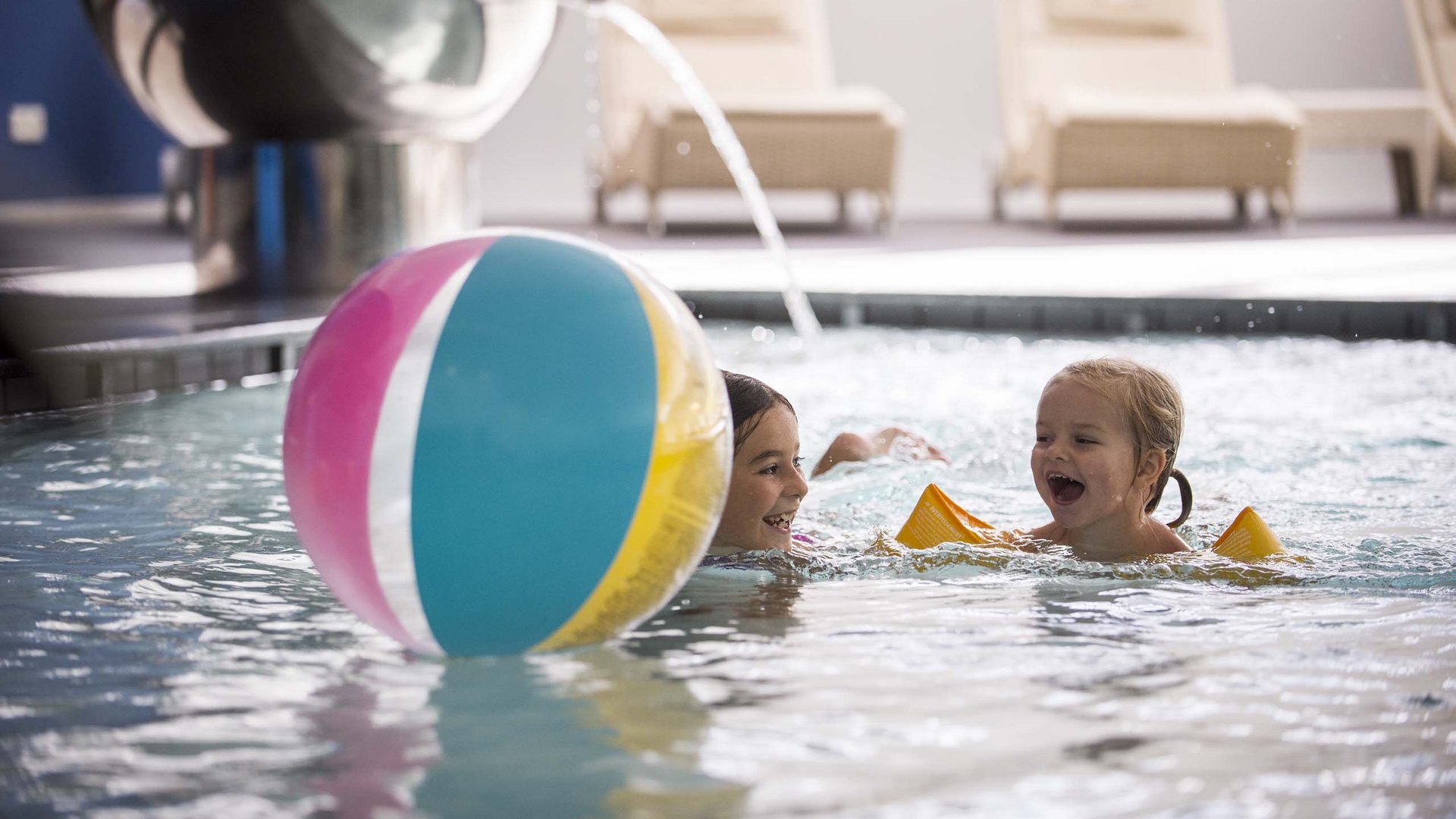 Family Resort Rainer Due bambini che giocano con una palla colorata in piscina