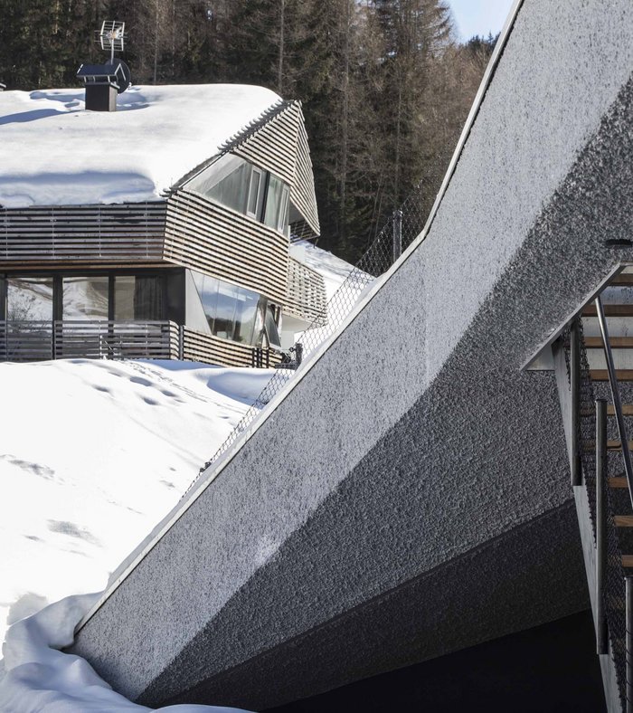 Modern house with wooden elements in a snowy forest