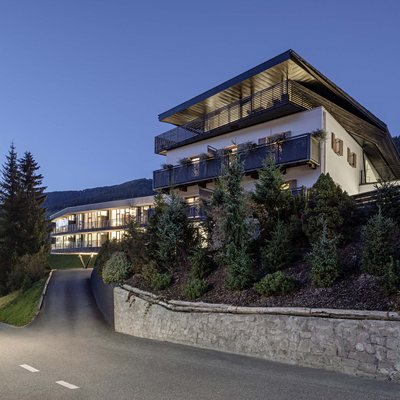 Edificio alberghiero moderno al crepuscolo in paesaggio montano