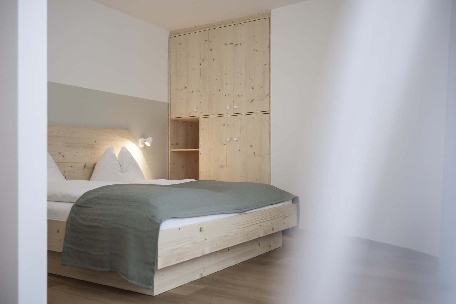 Naturerlebnis in der Villa Rainer Schlafzimmer mit Holzbett und Schrank, minimalistisch und hell