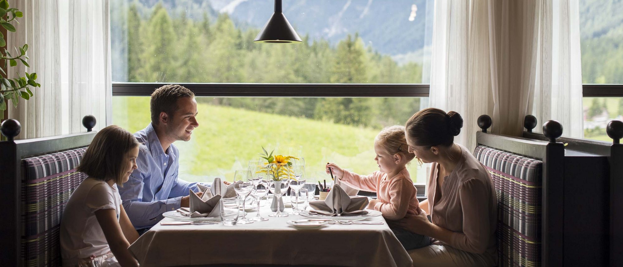 Gourmet delights from morning to night Family having meal in restaurant with mountain view