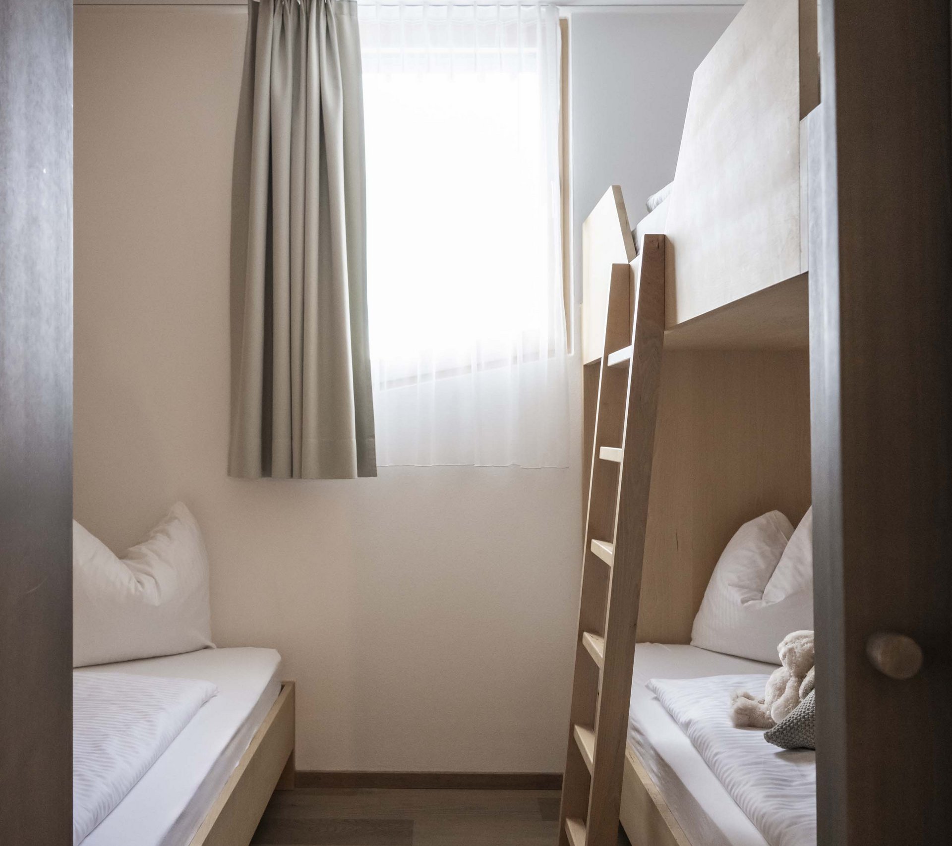 Betriebsdetailseite - Residence Villa Rainer Kleines Zimmer mit zwei Betten, einem Fenster und Holzleiter zu Etagenbett