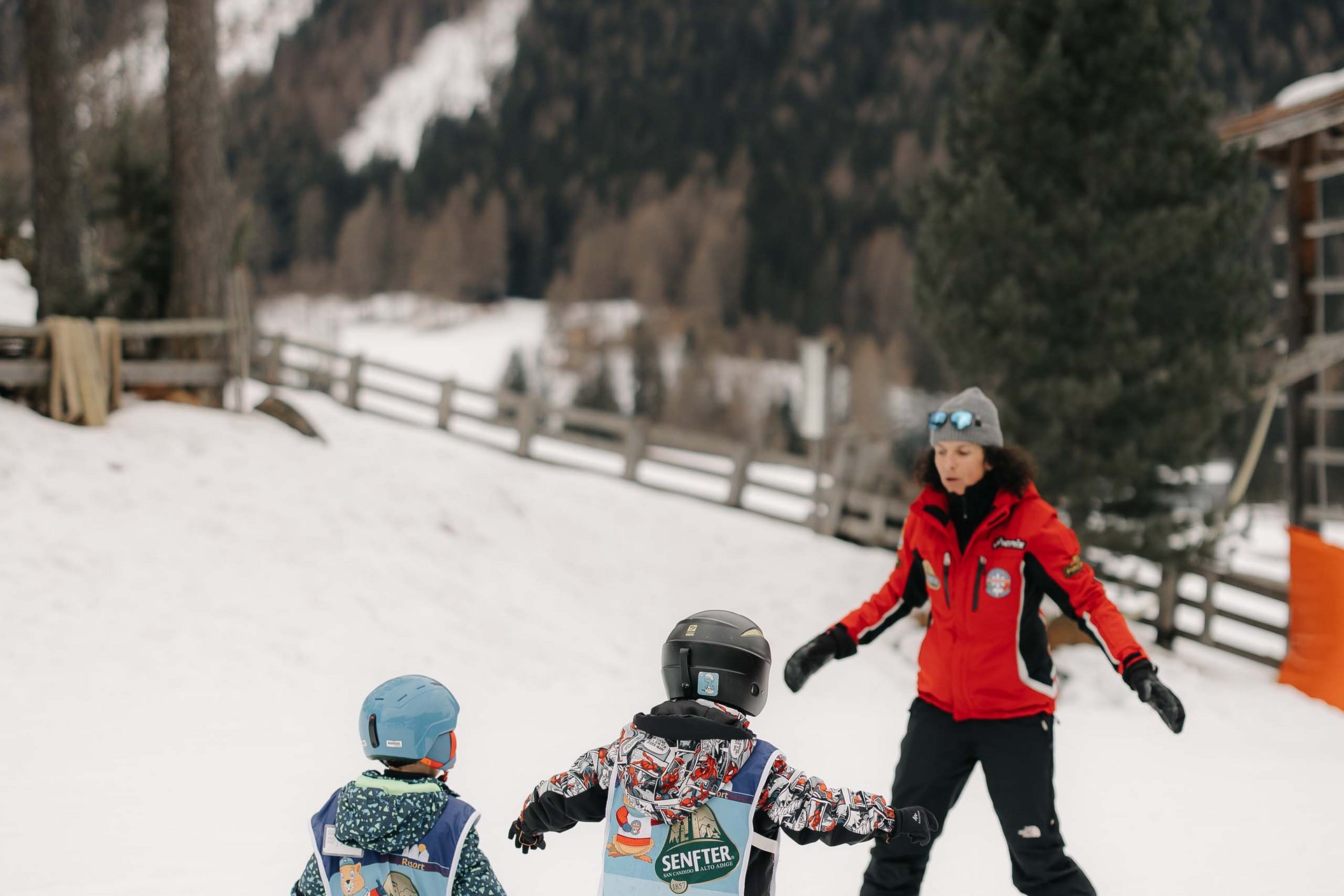 How to get to the Family Resort Rainer Ski instructor teaching two children skiing on a snowy slope