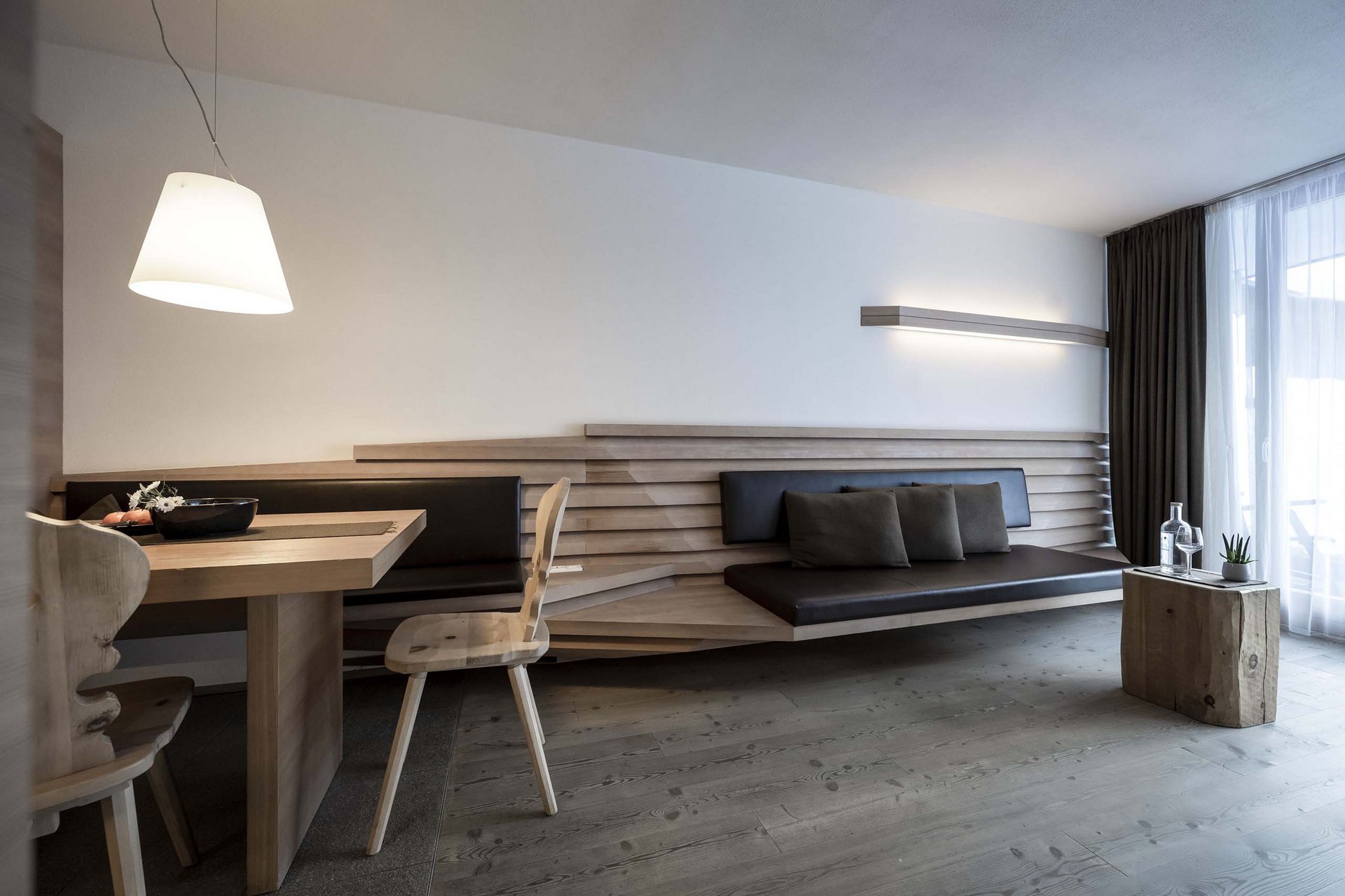 The Residence Königswarte Strata Modern living area with wooden bench, dining table, chairs, and lighting
