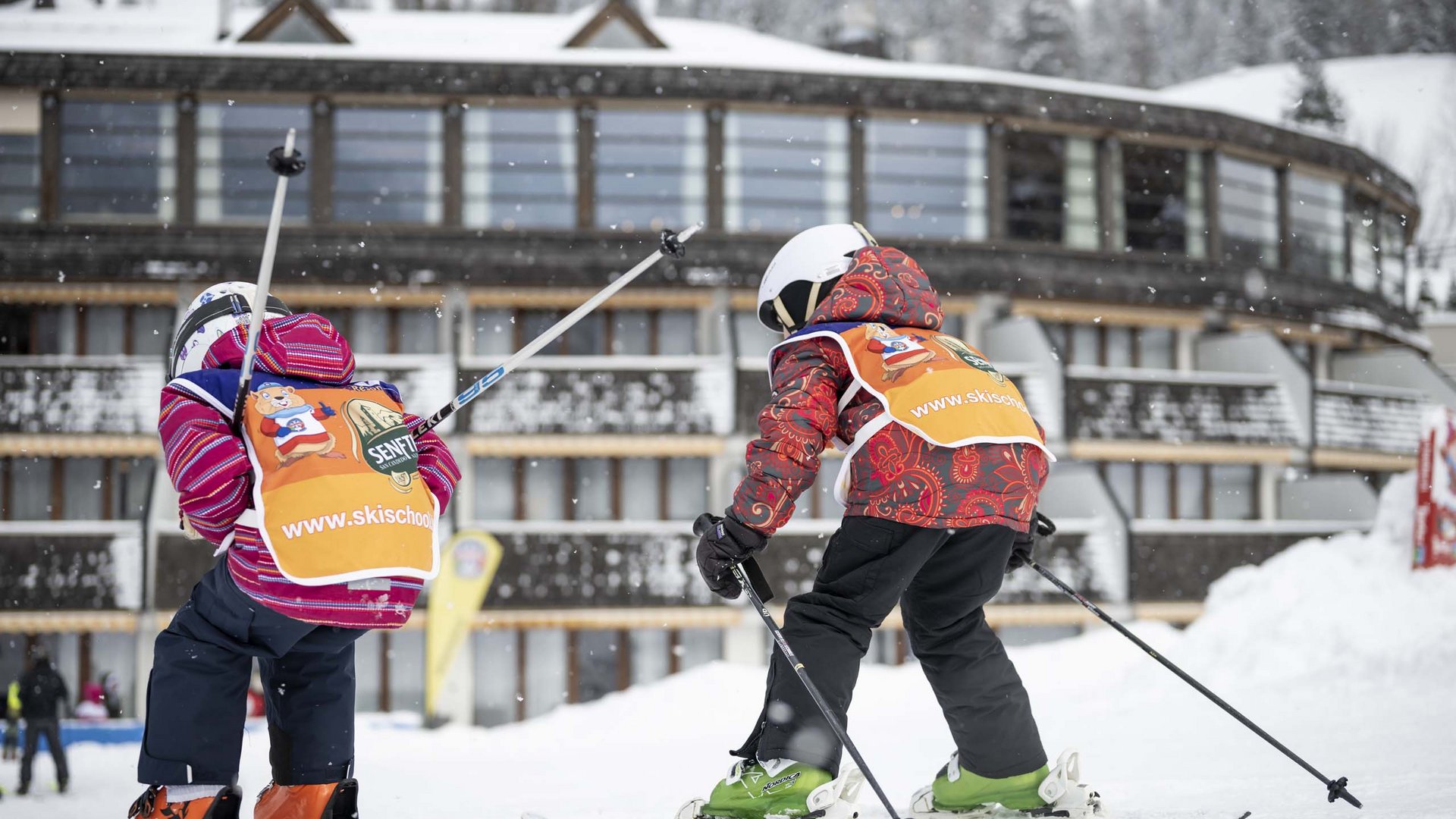 Qualche immagine del Rainer Due bambini che sciano davanti a un edificio con neve che cade