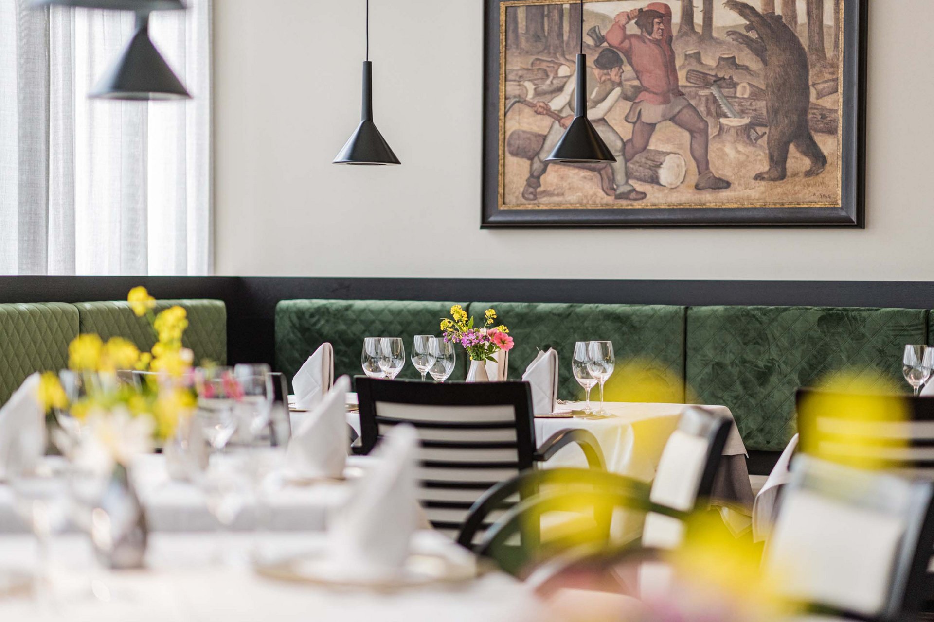 How to get to the Family Resort Rainer Elegant restaurant with set tables and painting on the wall