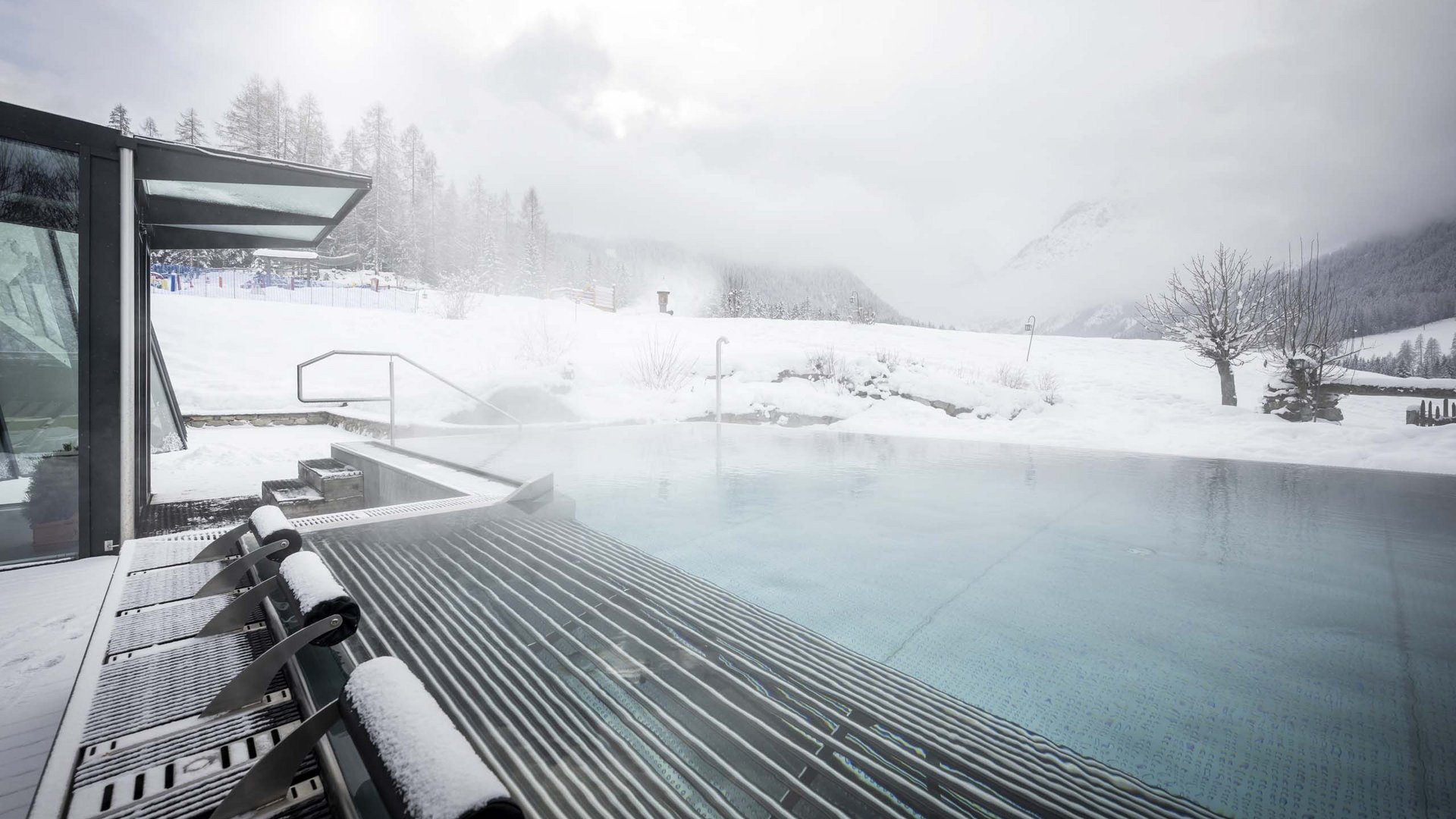 Family Resort Rainer Piscina riscaldata all'aperto con paesaggio invernale innevato sullo sfondo