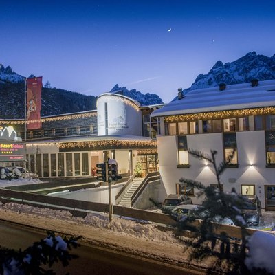 Hotel Family Resort Rainer innevato di notte con luci e montagne sullo sfondo