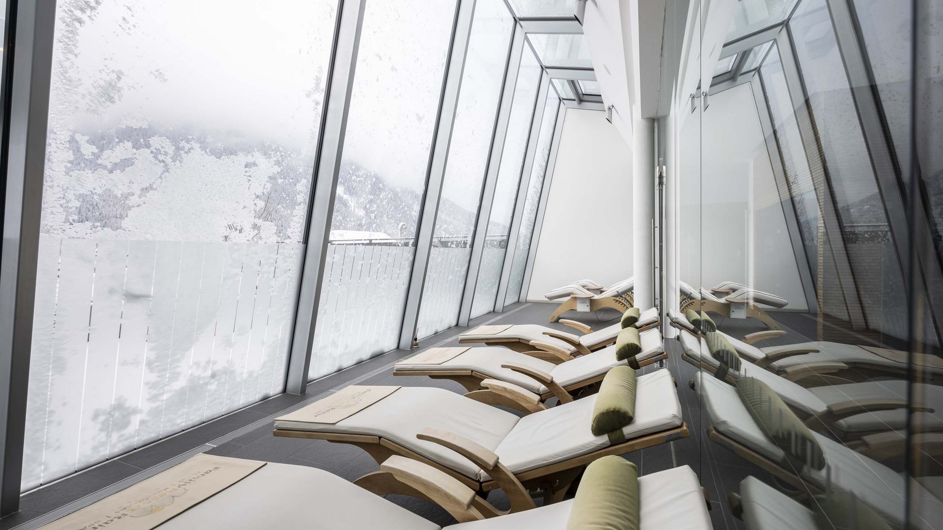 Family Resort Rainer Lettini in una sala benessere moderna con grandi finestre e montagne innevate
