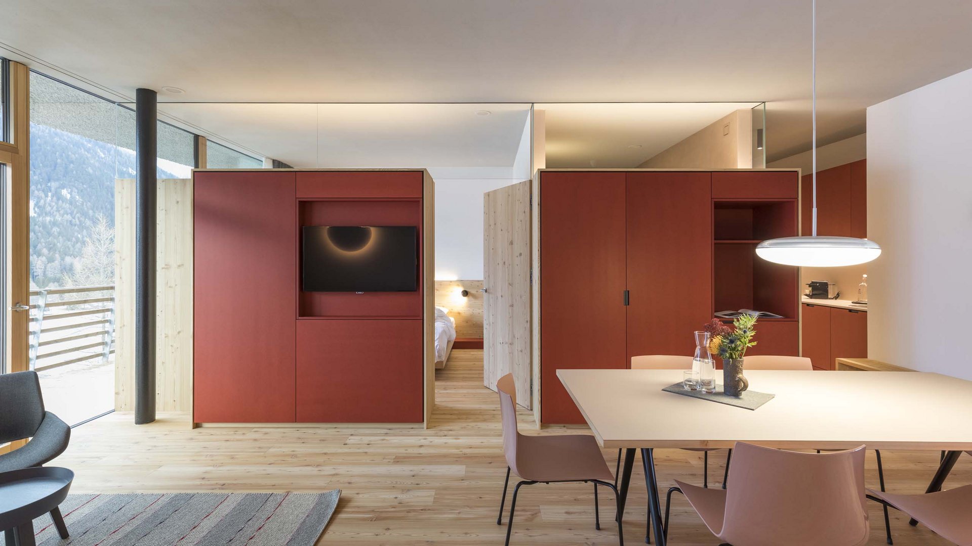 Residence Paramount Alma Appartamento moderno con pavimento in legno, armadio rosso e grande finestra con vista montagna