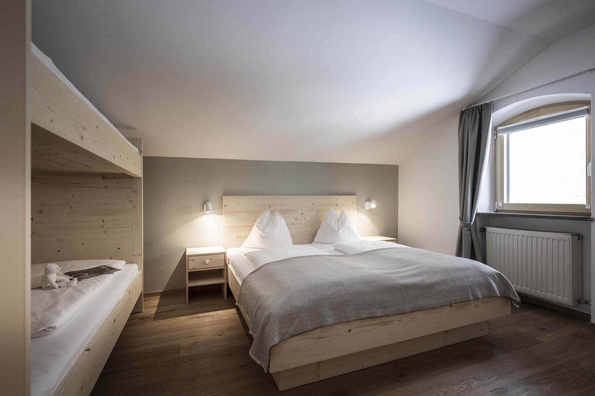 Naturerlebnis in der Villa Rainer Schlafzimmer mit Holzbetten, Doppelbett und Etagenbett, Fenster mit Vorhang