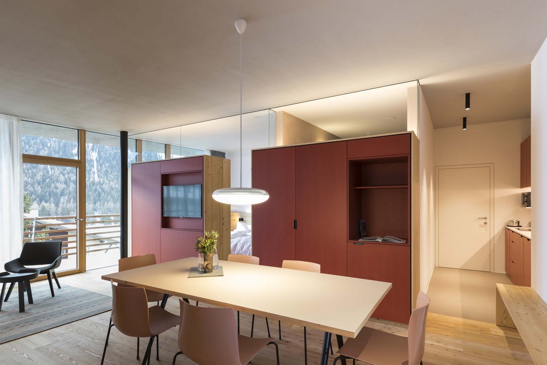 How to get to the Family Resort Rainer Modern dining area with light chairs, table, and red cabinet near window and balcony