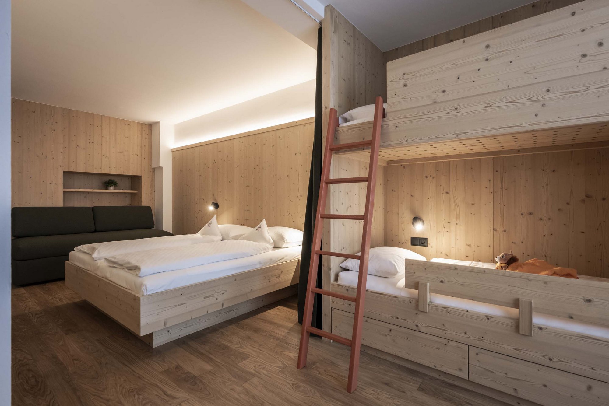 Family Resort Rainer: your accommodation in the Dolomites Room with double bed and bunk bed made of light wood