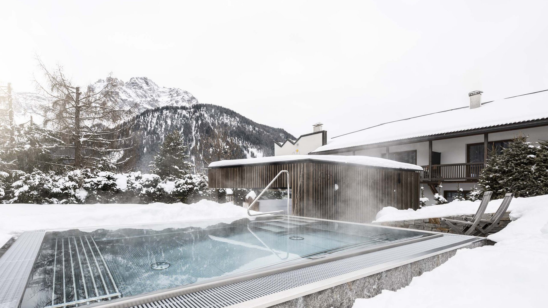 Residence Königswarte Strata Piscina riscaldata all'aperto in paesaggio montano innevato accanto a una casa