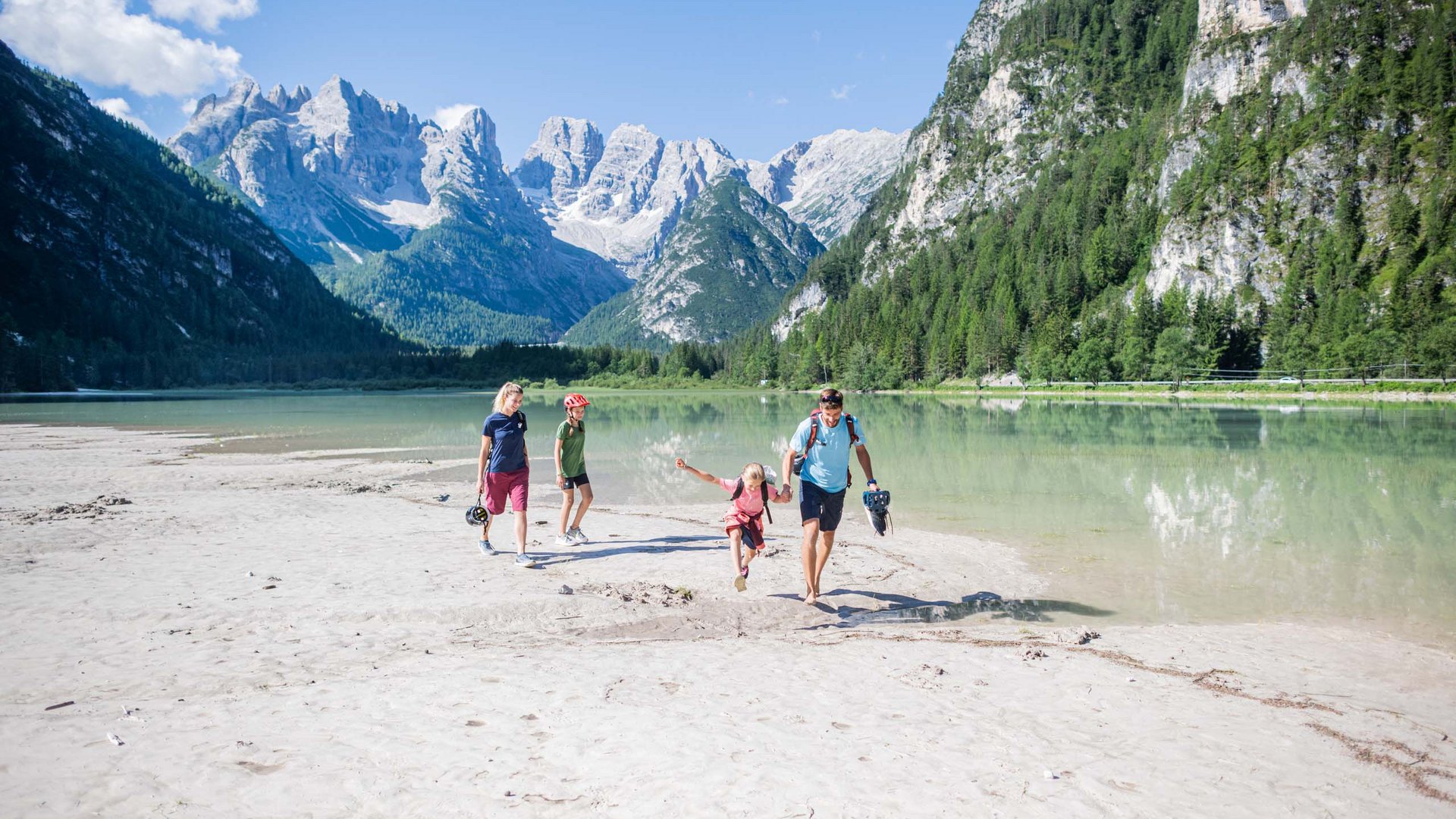 Qualche immagine del Rainer Famiglia cammina sulla riva del lago con vista sulle montagne