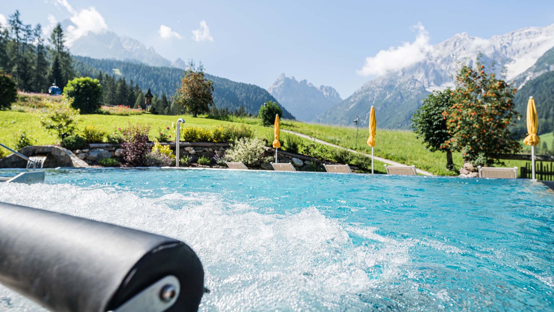 Family Resort Rainer Vasca idromassaggio con vista sulle montagne e sdraio in un prato verde