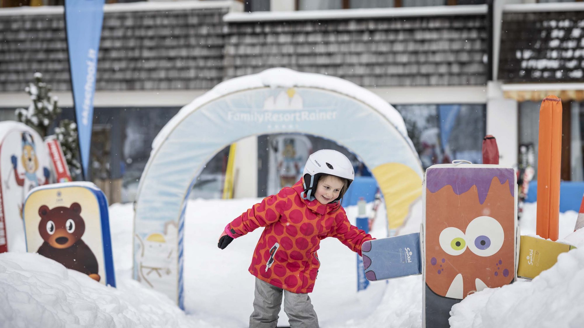 Our family experiences Child playing in snowy winter playground with colorful figures
