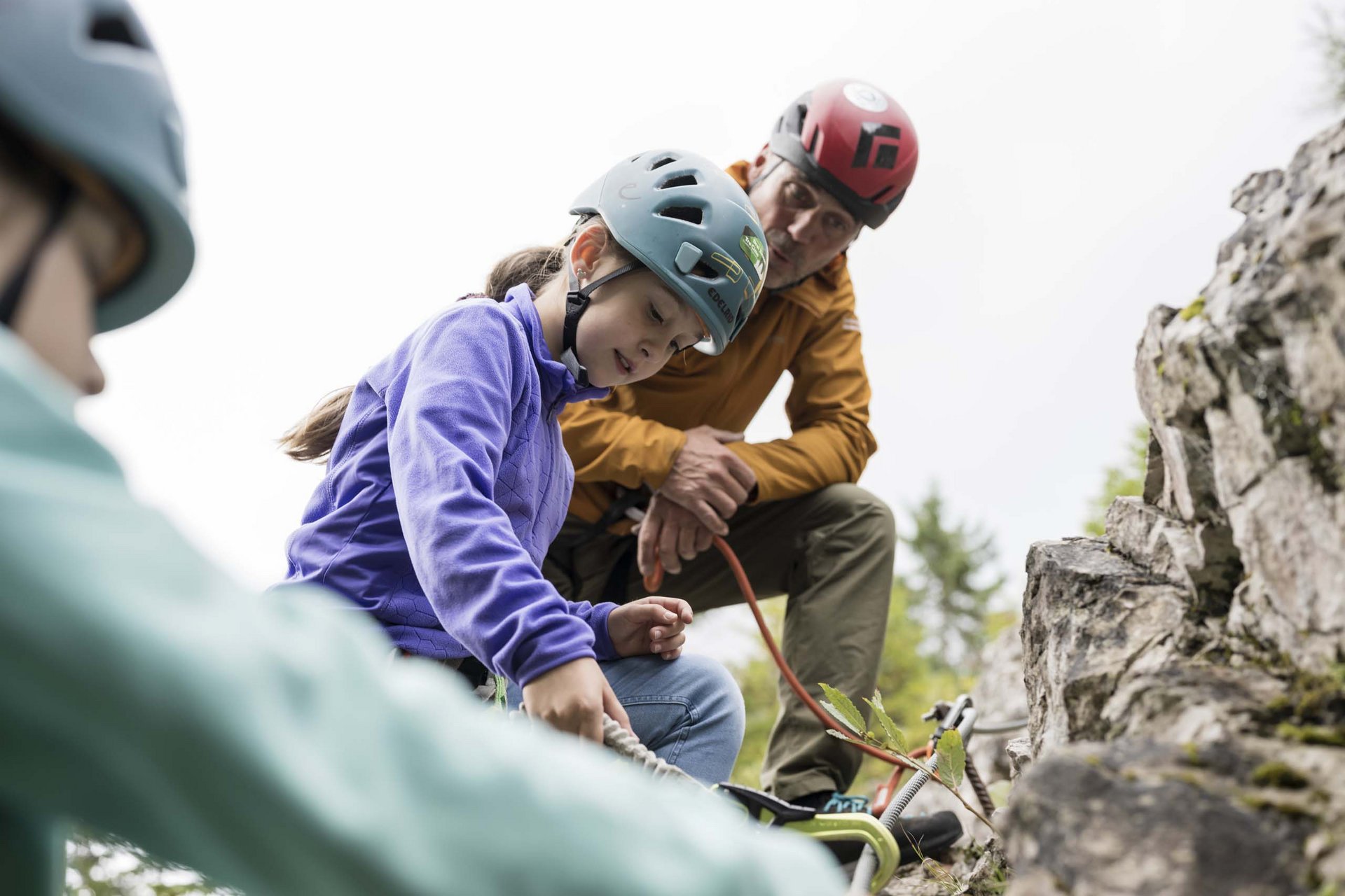 Il vostro family resort in Alto Adige Bambina impara a arrampicarsi su roccia con casco e attrezzatura sotto supervisione