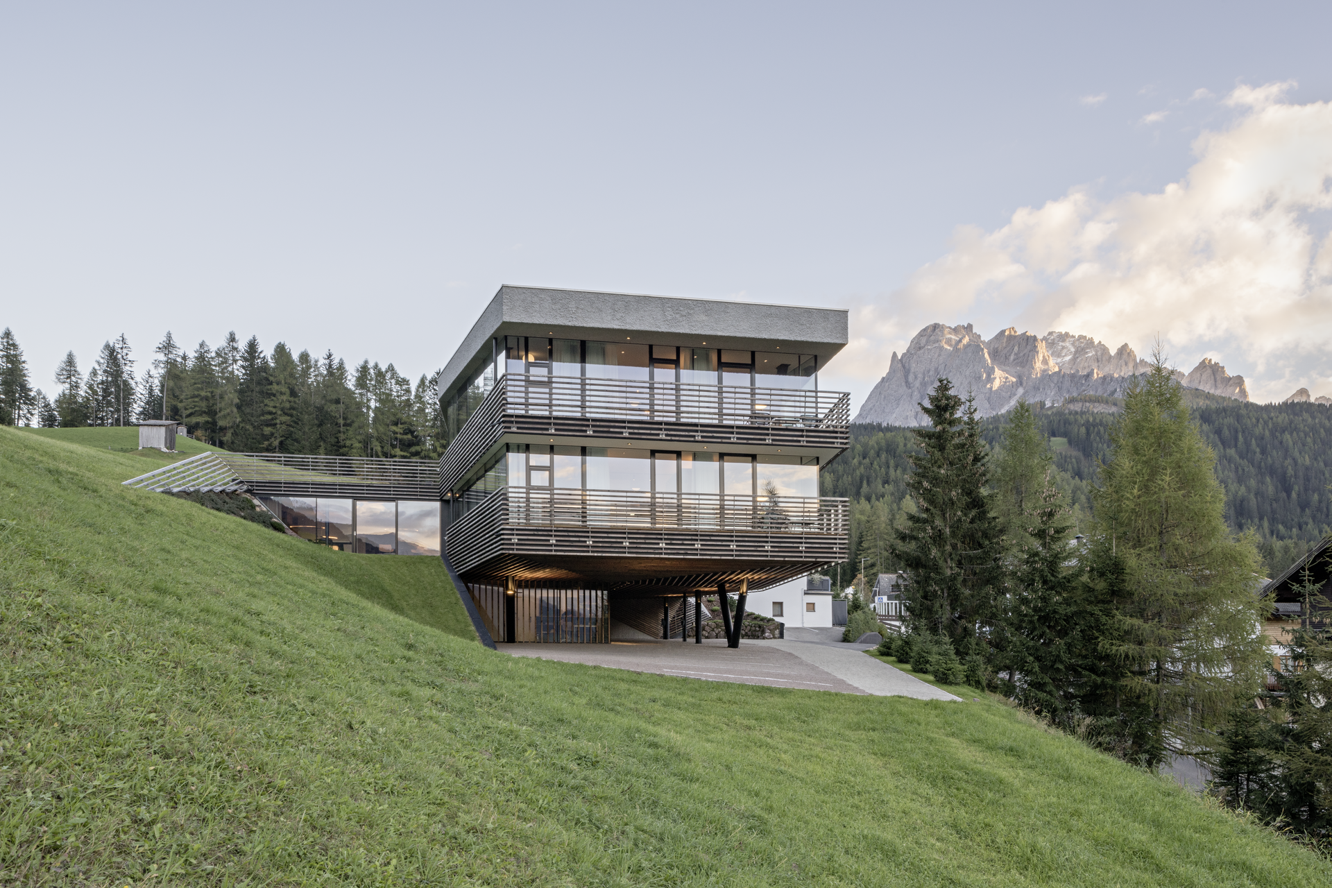 Modernes Haus mit großen Fenstern auf einem bewaldeten Hügel