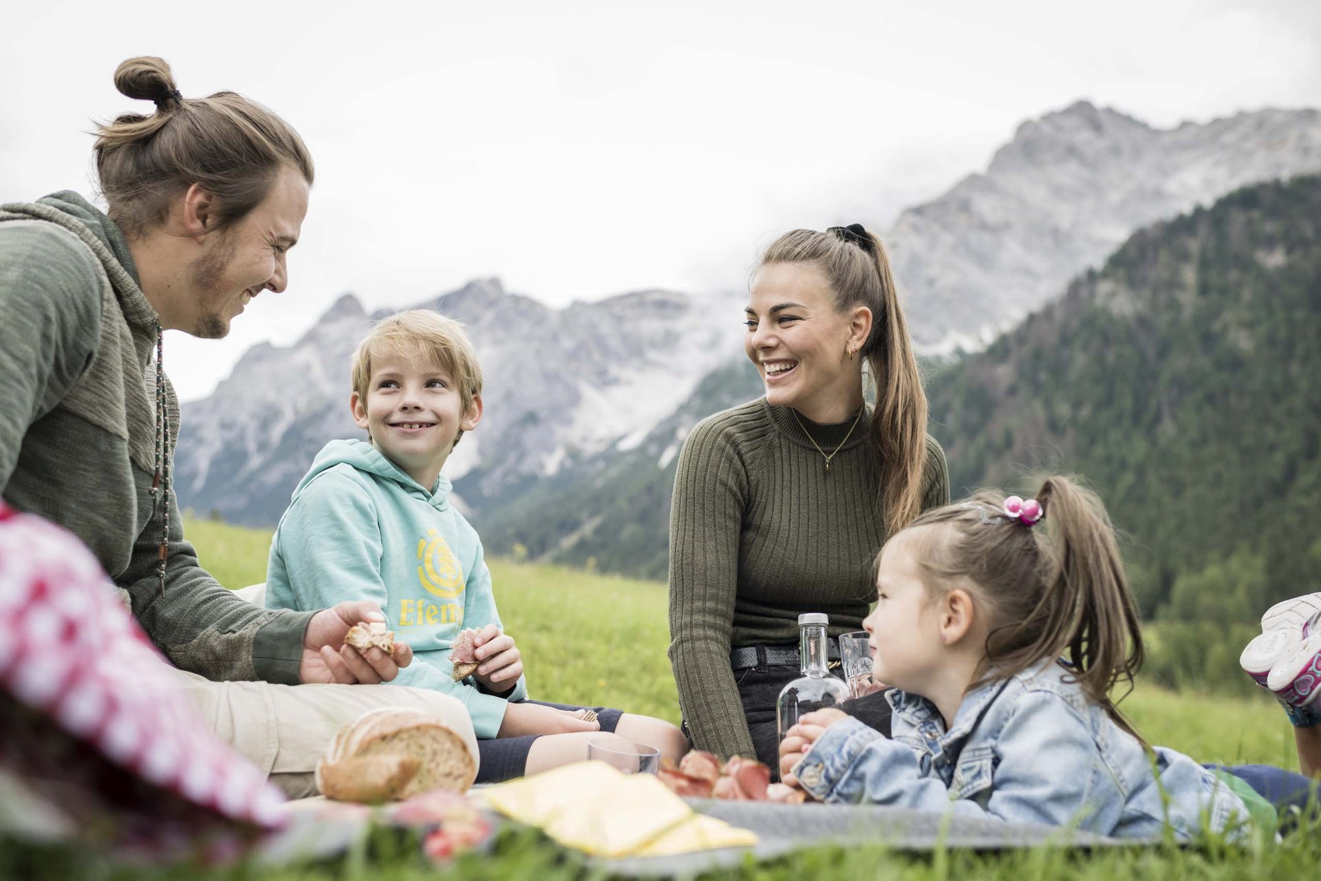 Il vostro family resort in Alto Adige Famiglia a picnic su un prato con montagne sullo sfondo