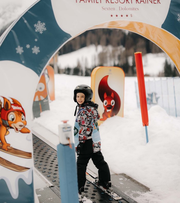 Our family experiences Child wearing ski helmet skiing at Family Resort Rainer in the snow